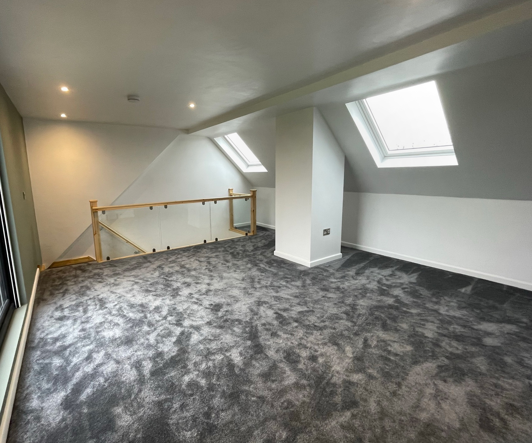 Spacious attic conversion with Velux roof light windows in Milton Keynes area. Complimented by a modern oak and glass staircase.